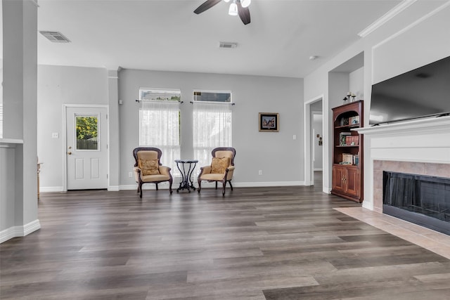 3731 Crescent Dr, Pearland, TX 77584 - living area featuring ceiling fan, a tile fireplace, built in features, and wood finished floors