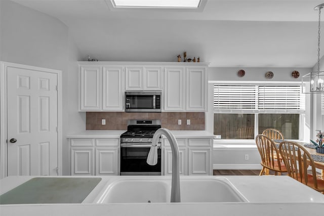 3731 Crescent Dr, Pearland, TX 77584 - kitchen with appliances with stainless steel finishes, white cabinetry, tasteful backsplash, light countertops, and vaulted ceiling