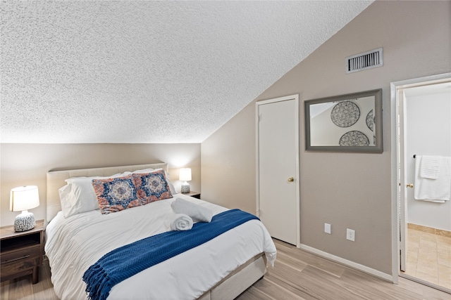 12900 Walden Rd Unit 706G, Montgomery, TX 77356 - bedroom with lofted ceiling, light wood-style floors, and a textured ceiling