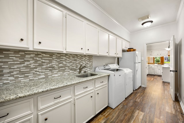 1267 Creekford Cir, Sugar Land, TX 77478 - laundry room featuring ornamental molding, washing machine and dryer, and dark wood-style flooring