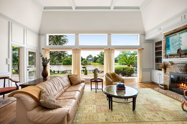 1267 Creekford Cir, Sugar Land, TX 77478 - living area featuring a water view, a fireplace, a towering ceiling, light wood finished floors, and ornamental molding