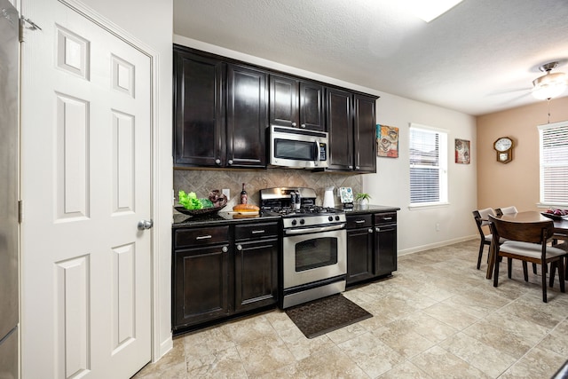 15110 Sierra Ridge Dr, Humble, TX 77396 - kitchen featuring appliances with stainless steel finishes, backsplash, dark countertops, a textured ceiling, and ceiling fan