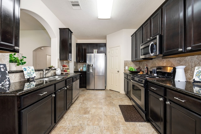 15110 Sierra Ridge Dr, Humble, TX 77396 - kitchen with appliances with stainless steel finishes, dark stone counters, and tasteful backsplash