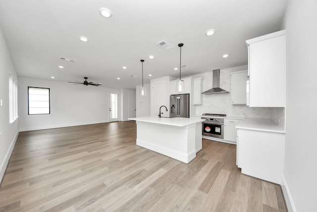 3217 Royal Oaks Hollow Ln, Houston, TX 77082 - kitchen featuring wall chimney range hood, stainless steel fridge with ice dispenser, oven, light countertops, and a ceiling fan