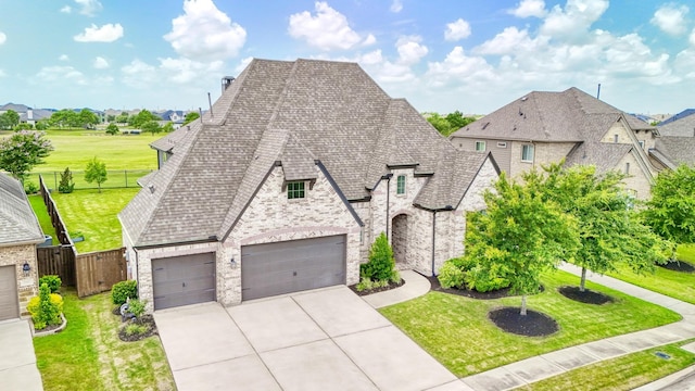 2607 Open Prairie Ln, Katy, TX 77493 - french country home with brick siding, concrete driveway, roof with shingles, a residential view, and a garage