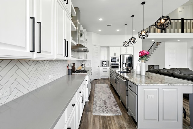 2607 Open Prairie Ln, Katy, TX 77493 - kitchen featuring stainless steel appliances, dark wood-style floors, white cabinets, a large island, and pendant lighting