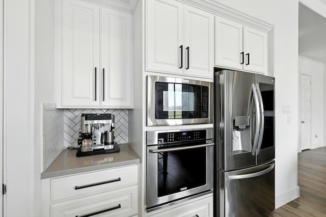 2607 Open Prairie Ln, Katy, TX 77493 - kitchen with stainless steel appliances, decorative backsplash, white cabinets, wood finished floors, and light countertops