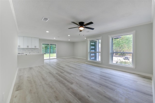 1221 Delores St, Kemah, TX 77565 - unfurnished living room with light wood-type flooring, ceiling fan, crown molding, recessed lighting, and a textured ceiling