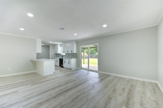1221 Delores St, Kemah, TX 77565 - unfurnished living room with recessed lighting, ornamental molding, and light wood-style floors