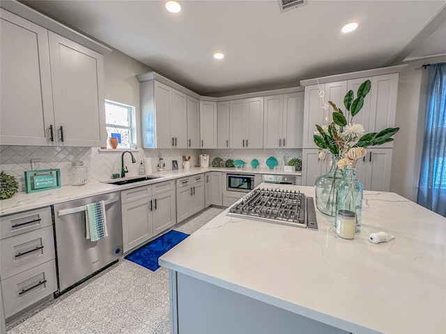 3128 Avenue N, Galveston, TX 77550 - kitchen featuring appliances with stainless steel finishes, decorative backsplash, light stone counters, and recessed lighting