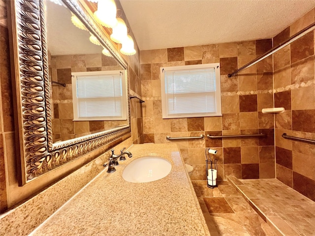 8009 Dellanera Dr, Hitchcock, TX 77563 - bathroom with tiled shower, vanity, and tile walls