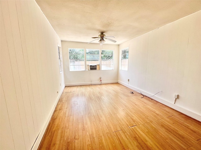 8009 Dellanera Dr, Hitchcock, TX 77563 - empty room with light wood-style flooring, ceiling fan, cooling unit, and a textured ceiling