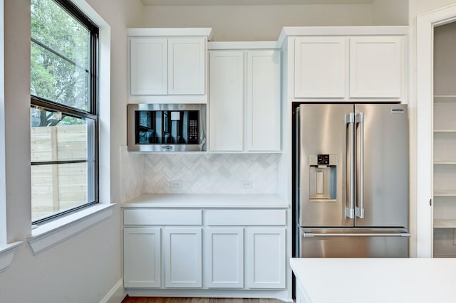 12008 Royal Oaks Banner Way, Houston, TX 77082 - kitchen featuring appliances with stainless steel finishes, light countertops, decorative backsplash, and white cabinets