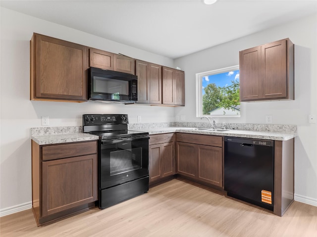 304 N Orange St, Sweeny, TX 77480 - kitchen with black appliances, light wood-style floors, and light countertops