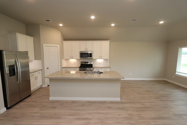 4989 Perennial Ln, La Marque, TX 77568 - kitchen with appliances with stainless steel finishes, light wood-style flooring, white cabinetry, a kitchen island with sink, and recessed lighting