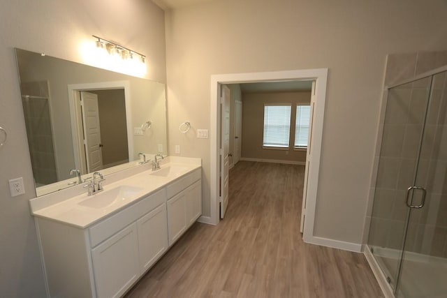 4989 Perennial Ln, La Marque, TX 77568 - bathroom featuring wood finished floors, double vanity, and a tile shower