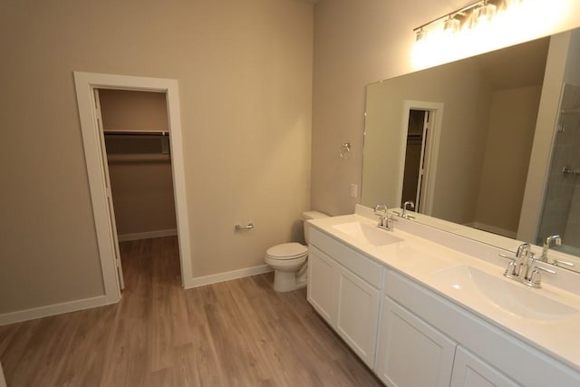 4989 Perennial Ln, La Marque, TX 77568 - bathroom featuring double vanity, a walk in closet, wood finished floors, and a shower with shower door