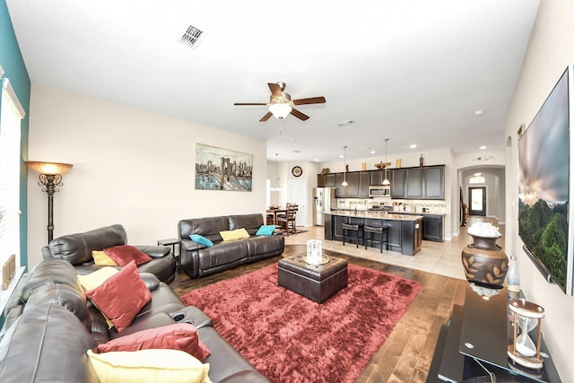 9430 Jayci Hills Ln, Cypress, TX 77433 - living room featuring ceiling fan, light wood finished floors, recessed lighting, and arched walkways