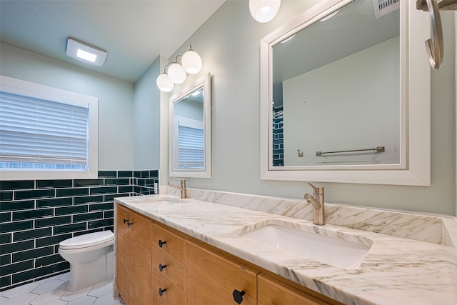 6206 San Felipe St, Houston, TX 77057 - bathroom with tile walls, double vanity, tile patterned flooring, and a wainscoted wall