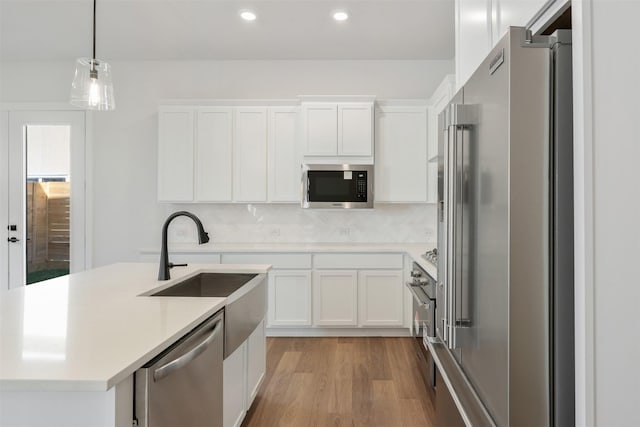 3223 Royal Oaks Hollow Ln, Houston, TX 77082 - kitchen with appliances with stainless steel finishes, light wood-type flooring, light countertops, white cabinetry, and recessed lighting