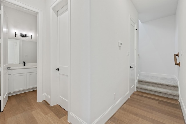 3223 Royal Oaks Hollow Ln, Houston, TX 77082 - hallway featuring light wood-style floors and a sink