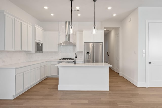 3223 Royal Oaks Hollow Ln, Houston, TX 77082 - kitchen featuring stainless steel fridge, wall chimney range hood, backsplash, white cabinets, and recessed lighting