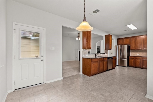 621 Rocky Hollow Ln, League City, TX 77573 - kitchen featuring appliances with stainless steel finishes, decorative backsplash, brown cabinets, and decorative light fixtures