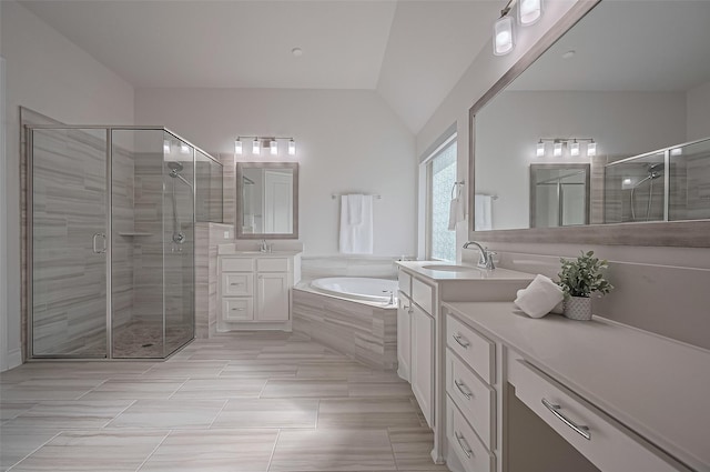 2430 Sunflower Cove Ln, Brookshire, TX 77423 - bathroom featuring a garden tub, two vanities, a stall shower, vaulted ceiling, and tile patterned floors