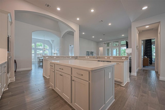 2430 Sunflower Cove Ln, Brookshire, TX 77423 - kitchen featuring a center island, dark wood-style floors, arched walkways, light countertops, and recessed lighting