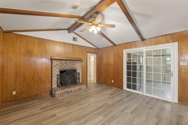 746 Fawn Dr, Houston, TX 77015 - unfurnished living room featuring wooden walls, light wood-type flooring, ceiling fan, and a brick fireplace
