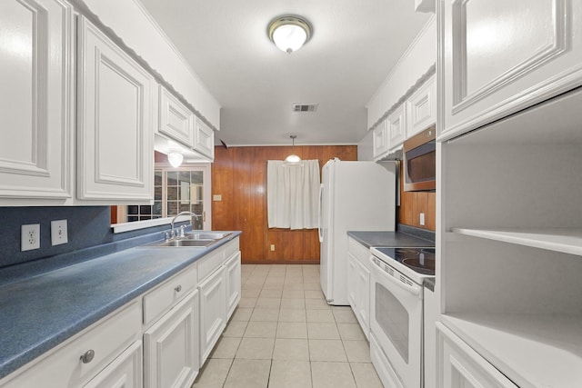 746 Fawn Dr, Houston, TX 77015 - kitchen with stainless steel appliances, white cabinets, wooden walls, light tile patterned floors, and dark countertops