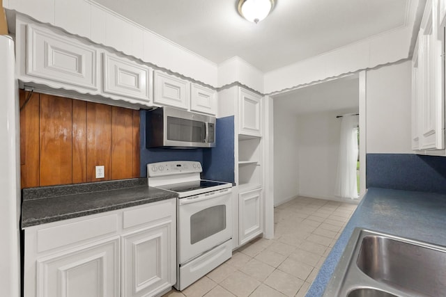 746 Fawn Dr, Houston, TX 77015 - kitchen featuring white electric range, stainless steel microwave, light tile patterned floors, white cabinetry, and dark countertops