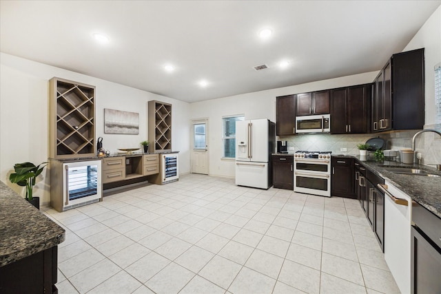 1516 Foshee Ct, Alvin, TX 77511 - kitchen with white appliances, beverage cooler, backsplash, dark stone countertops, and recessed lighting