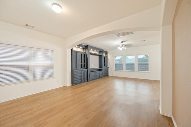 2827 Arica Ln, Spring, TX 77373 - unfurnished living room with ceiling fan, arched walkways, and light wood-style floors