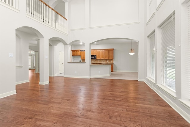 14015 Halprin Creek Dr, Cypress, TX 77429 - unfurnished living room with healthy amount of natural light, a towering ceiling, and wood finished floors
