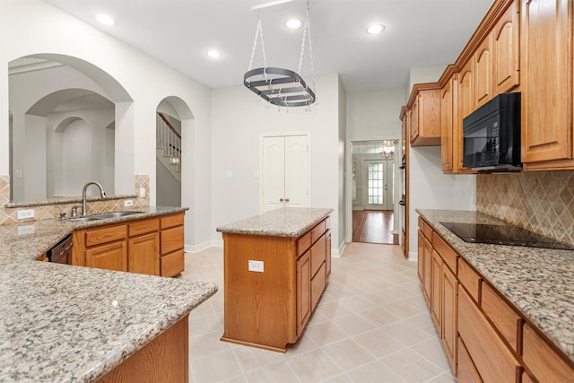 14015 Halprin Creek Dr, Cypress, TX 77429 - kitchen with black appliances, a center island, light stone countertops, decorative backsplash, and light tile patterned floors