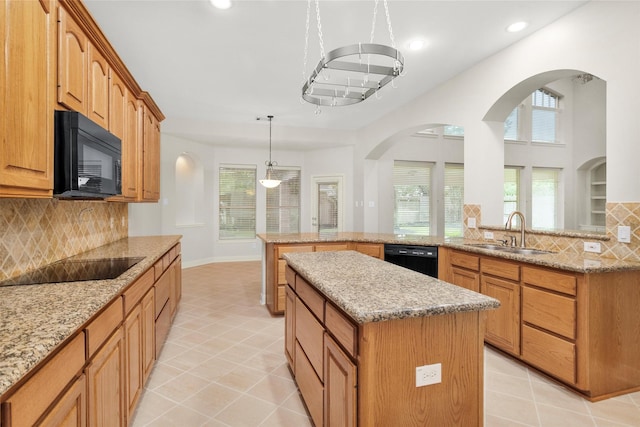 14015 Halprin Creek Dr, Cypress, TX 77429 - kitchen with black appliances, a kitchen island, decorative backsplash, recessed lighting, and light stone counters