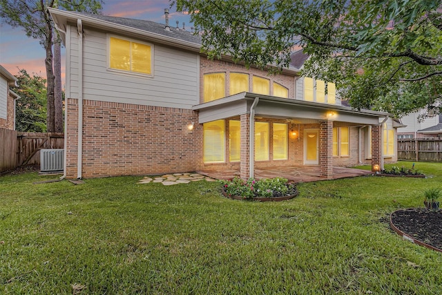 14015 Halprin Creek Dr, Cypress, TX 77429 - back of property at dusk featuring brick siding, a fenced backyard, and a patio area