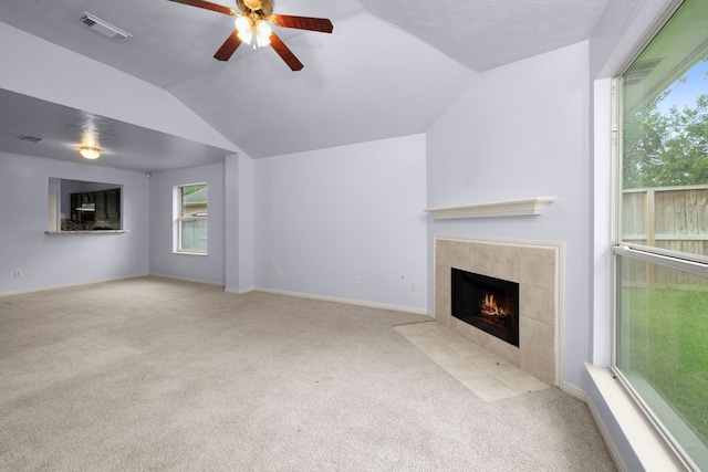 15819 Nutcracker Ct, Humble, TX 77396 - unfurnished living room featuring a tiled fireplace, carpet, vaulted ceiling, and ceiling fan