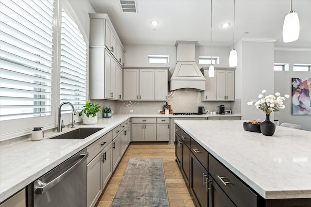 846 Dunleigh Meadows Ln, Houston, TX 77055 - kitchen featuring dishwasher, a center island, light wood-type flooring, decorative backsplash, and light stone counters
