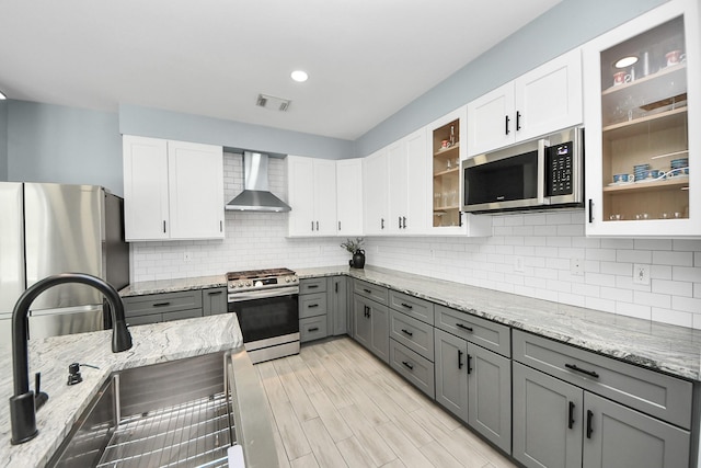7619 Park Sage Ln, Cypress, TX 77433 - kitchen with stainless steel appliances, wall chimney range hood, gray cabinets, decorative backsplash, and recessed lighting