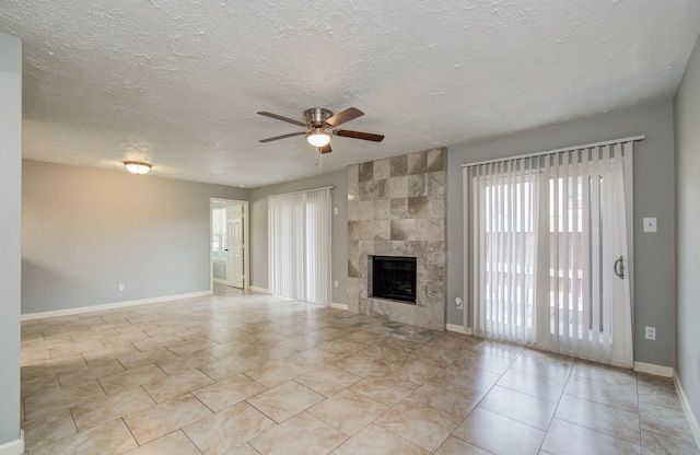 10555 Turtlewood Ct Unit 2802, Houston, TX 77072 - unfurnished living room with a ceiling fan, a textured ceiling, a tiled fireplace, and light tile patterned floors