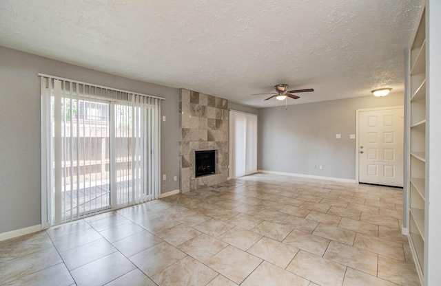 10555 Turtlewood Ct Unit 2802, Houston, TX 77072 - unfurnished living room with ceiling fan, a textured ceiling, light tile patterned flooring, and a fireplace