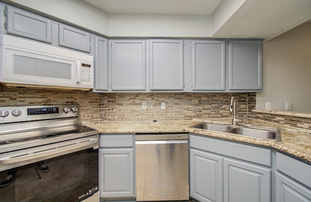 10555 Turtlewood Ct Unit 2802, Houston, TX 77072 - kitchen with stainless steel appliances, decorative backsplash, gray cabinetry, and light stone counters