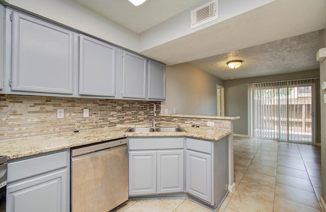 10555 Turtlewood Ct Unit 2802, Houston, TX 77072 - kitchen featuring dishwasher, backsplash, a peninsula, light tile patterned floors, and light stone counters