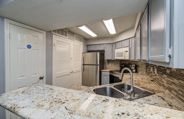 10555 Turtlewood Ct Unit 2802, Houston, TX 77072 - kitchen featuring appliances with stainless steel finishes, gray cabinetry, and tasteful backsplash