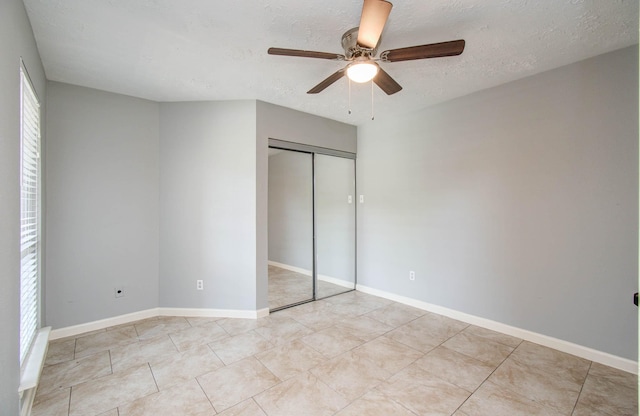 10555 Turtlewood Ct Unit 2802, Houston, TX 77072 - unfurnished bedroom featuring a closet, a textured ceiling, ceiling fan, and light tile patterned floors