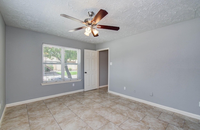 10555 Turtlewood Ct Unit 2802, Houston, TX 77072 - empty room featuring a textured ceiling, ceiling fan, and light tile patterned floors