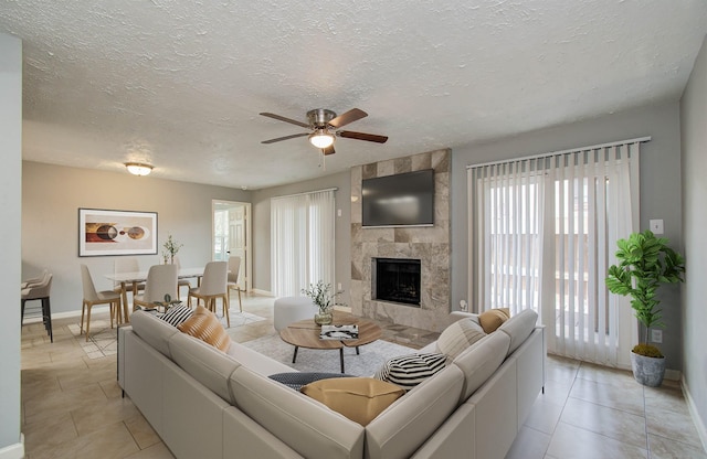 10555 Turtlewood Ct Unit 2802, Houston, TX 77072 - living room featuring light tile patterned floors, a ceiling fan, healthy amount of natural light, a textured ceiling, and a tile fireplace