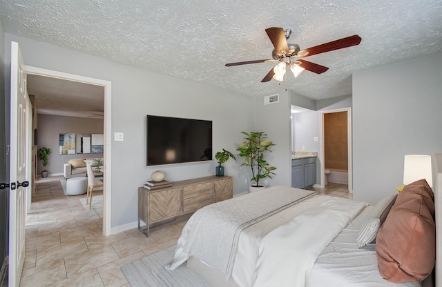 10555 Turtlewood Ct Unit 2802, Houston, TX 77072 - bedroom featuring a textured ceiling, light tile patterned floors, ensuite bath, and ceiling fan